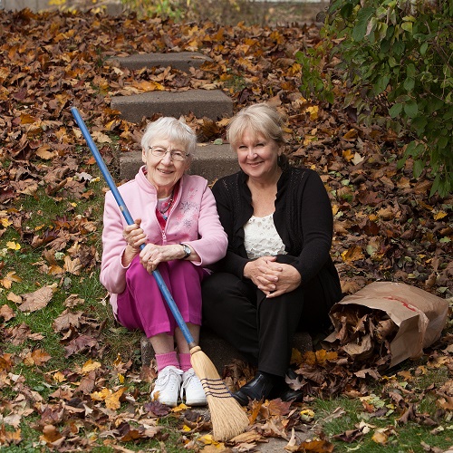 Women together raking leaves.